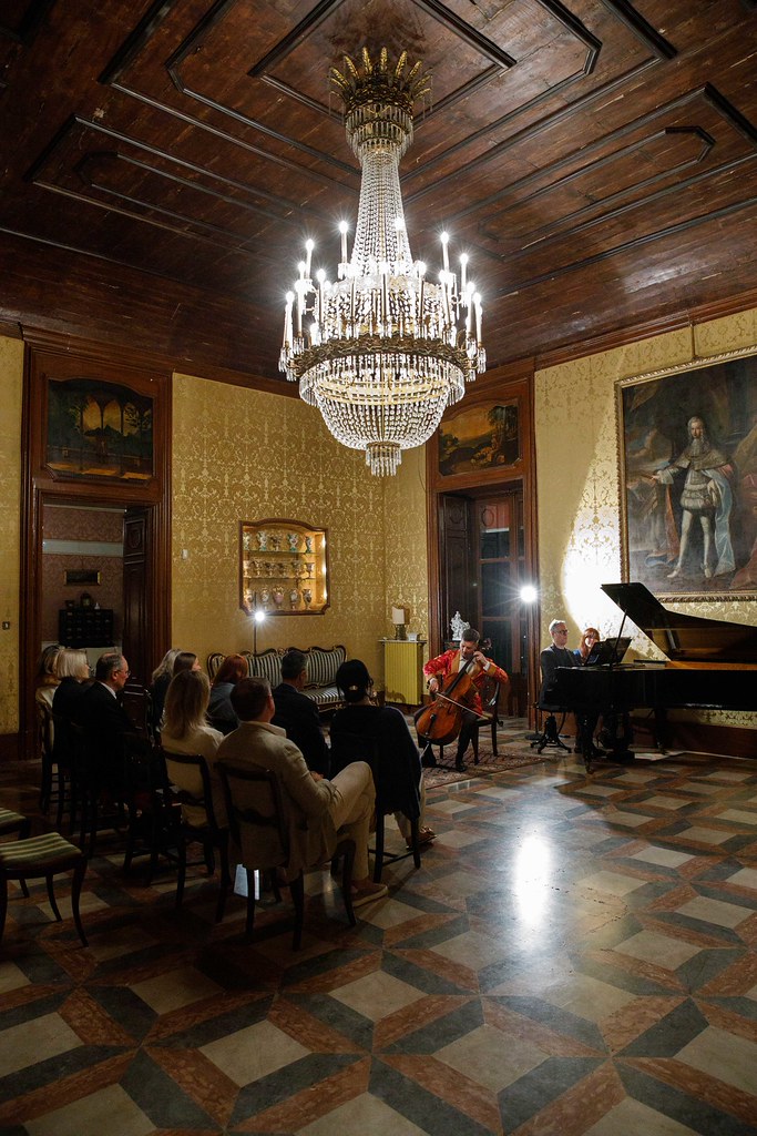 Max Beitan performing on a historical Italian cello within a heritage salon